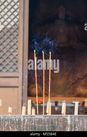 Räucherstäbchen vor Buddha Stockfoto