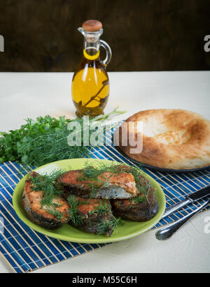 Gebratener Fisch mit Gruenen und Olivenöl ländlichen Tabelle Stockfoto