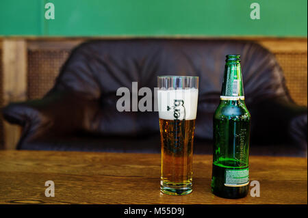 Hai, der Ukraine - 08. November 2017: Carlsberg Bier Flasche und Pint auf dem hölzernen Tisch in barbershop Witt grüne Wände. Stockfoto