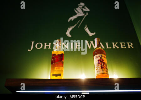 Hai, der Ukraine - 08. November 2017: zwei Flaschen Alkohol Getränke Red Label und Captain Morgan auf die hölzerne Oberfläche mit grünen Wand mit einer Inscriptio Stockfoto