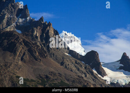 Ein Gletscher bedeckte Gipfel, stößt hinter den gezackten Granit ridge Line des Gebirges, im Torres del Paine Nationalpark in Patagonien Stockfoto