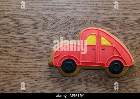 Nahaufnahme von roten Lebkuchen Auto gelegen auf dem hölzernen Tisch Hintergrund Stockfoto