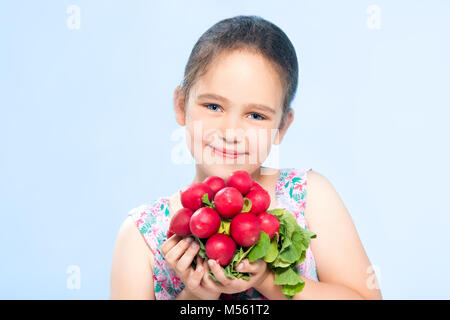 Fröhliche kaukasische Mädchen hält einen Rettich Stockfoto