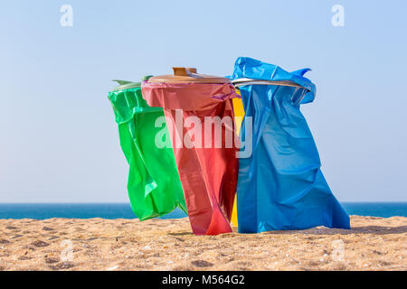 Bunte Müllsäcke am Strand an der Küste Stockfoto