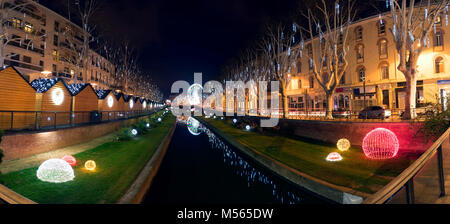 Nacht Ansicht der Stadt von Perpignan (Frankreich) während der Weihnachtszeit. Schöne Lichter und die Berührung einer eine Messe mit ein großes Rad im Rücken. Stockfoto