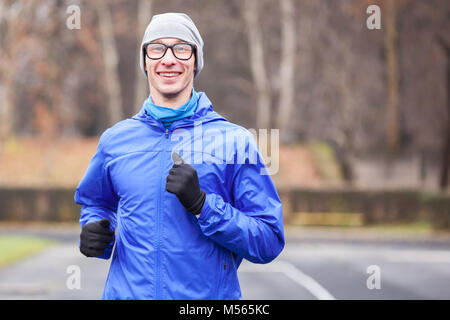 7/8 Der glückliche junge Mann laufen im Freien. Stockfoto