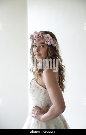 Porträt einer schönen Modell Tragen eines weißen Designer Wedding Dress - einfacher weißer Hintergrund & Fenster Beleuchtung Stockfoto