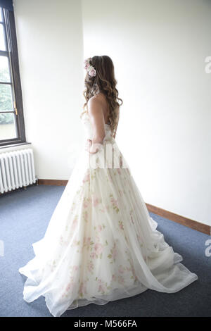 Porträt einer schönen Modell Tragen eines weißen Designer Wedding Dress - einfacher weißer Hintergrund & Fenster Beleuchtung Stockfoto