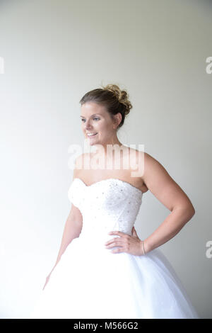Porträt einer schönen Modell Tragen eines weißen Designer Wedding Dress - einfacher weißer Hintergrund & Fenster Beleuchtung Stockfoto