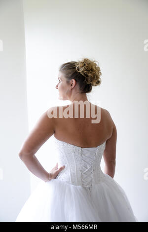 Porträt einer schönen Modell Tragen eines weißen Designer Wedding Dress - einfacher weißer Hintergrund & Fenster Beleuchtung Stockfoto