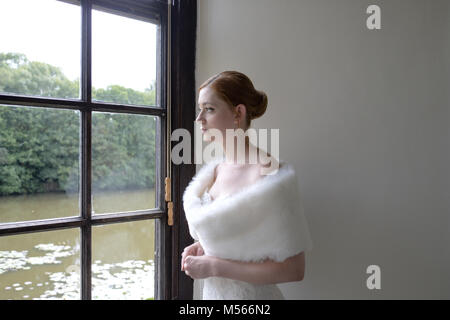 Porträt einer schönen Modell Tragen eines weißen Designer Wedding Dress - einfacher weißer Hintergrund & Fenster Beleuchtung Stockfoto