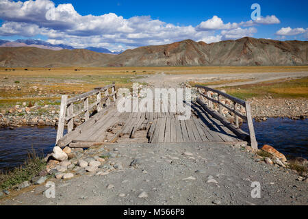 Abgenutzte hölzerne Brücke über einen Feldweg bei Altai Gebirge, der westlichen Mongolei Stockfoto