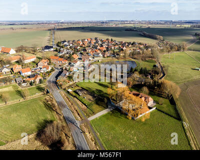 Luftaufnahme von einem Dorf in der Nähe von Wolfsburg. Mit der Hauptstraße im Vordergrund und eine Farm mit einem Teich am Rande des Dorfes. Mit drone Gemacht Stockfoto