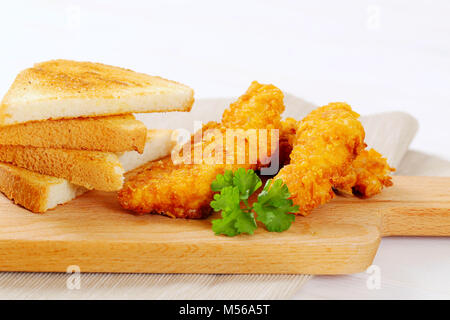 Hähnchen Schnitzel mit Toast auf Holz Schneidebrett - Nahaufnahme Stockfoto