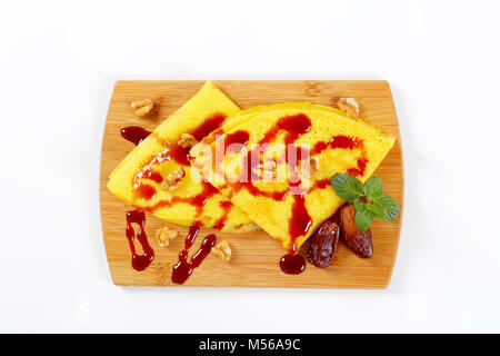 Pfannkuchen mit Walnüssen und Termine mit Datum Sirup auf Holz Schneidebrett gekrönt Stockfoto