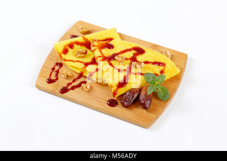 Pfannkuchen mit Walnüssen und Termine mit Datum Sirup auf Holz Schneidebrett gekrönt Stockfoto