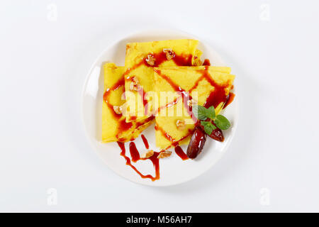 Pfannkuchen mit Walnüssen und Termine mit Datum Sirup auf weiße Platte gekrönt Stockfoto