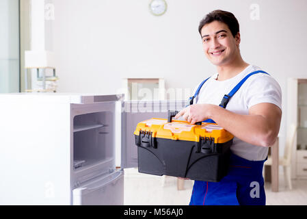 Handwerker Auftragnehmer Instandsetzung Kühlschrank im DIY-Konzept Stockfoto