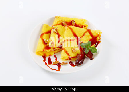 Pfannkuchen mit Walnüssen und Termine mit Datum Sirup auf weiße Platte gekrönt Stockfoto