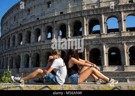 Rom, Italien: Ein junges Paar sitzt vor dem Kolosseum in Rom Stockfoto