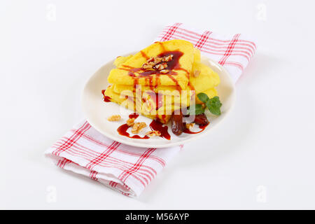 Pfannkuchen mit Walnüssen und Termine mit Datum Sirup auf weiße Platte gekrönt Stockfoto