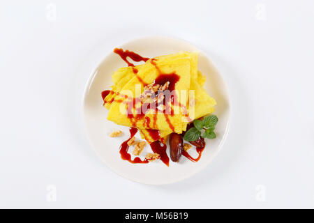 Pfannkuchen mit Walnüssen und Termine mit Datum Sirup auf weiße Platte gekrönt Stockfoto