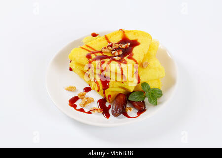 Pfannkuchen mit Walnüssen und Termine mit Datum Sirup auf weiße Platte gekrönt Stockfoto