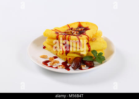 Pfannkuchen mit Walnüssen und Termine mit Datum Sirup auf weiße Platte gekrönt Stockfoto