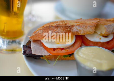 Ein Schinken Club Sandwich und Bier in ein Café im Freien in Paris Frankreich mit Tomaten, hart gekochte Eier, auf ein frisches Baguette. Stockfoto