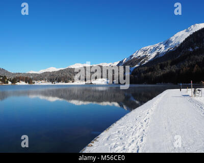 Schöner Spaziergang rund um einen See in der Nähe von Davos, Switzelrand. See, Schnee, Berge, Winter Wonderland. Stockfoto