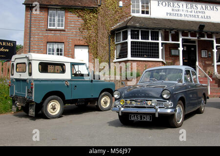 1961 Hillman Minx und Land Rover Serie IIA klassische britische Autos außerhalb eines Country Pub Stockfoto