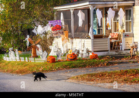 Ein Zuhause ist mit Geister, Kobolde und andere Halloween Dekorationen eingerichtet wie eine schwarze Katze, die Straße in Lissabon, NH, USA überquert. Stockfoto