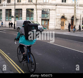 Ein Uber isst Lieferung Radfahrer mit back pack Lieferung von Nahrung in London Radfahren auf der Straße. Stockfoto