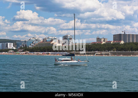 Gelendschik, die Region Krasnodar, Russland - Juli 17, 2015: Weiße Yacht in das Schwarze Meer auf einem Hintergrund Wohnanlage 'Wasser' in Gelendschik Stockfoto