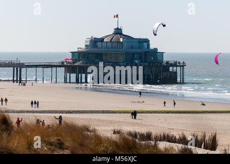 Blick auf den Pier Blankenberge im Frühjahr mit einigen Kitesurfer, um einen Menschen zu Fuß auf den Strand Stockfoto