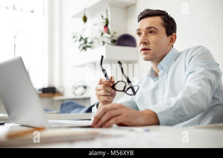 Nachdenklich Arbeitgeber arbeiten auf seinem Laptop Stockfoto