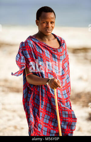 Stone Town, Sansibar - Januar 20, 2015: Afrikanische Mann stand auf einem Strand in ein Tuch gewickelt Stockfoto