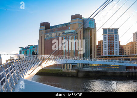 Newcastle Architektur, zwei Leute über die Millennium Bridge in Richtung der Baltischen Zentrum für Zeitgenössische Kunst in Gateshead, England, UK zu Fuß Stockfoto