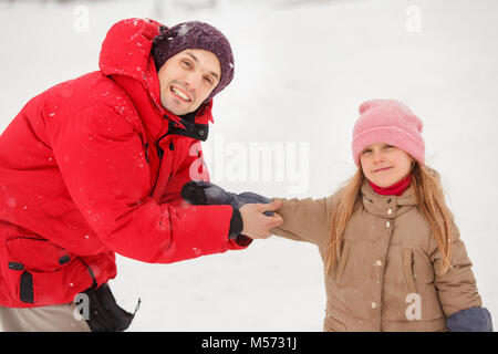 Bild Der glückliche Vater dressing seiner Tochter mitten im Winter Park Stockfoto