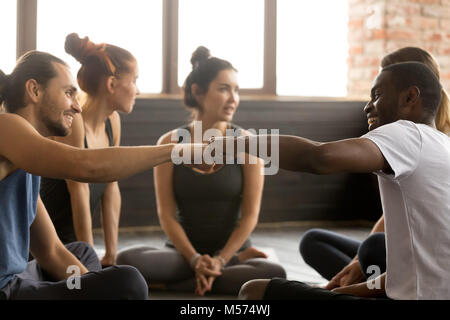 African American und kaukasischen Männern Faust stoßen bei Gruppe Trainin Stockfoto