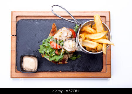 Spieße mit Fleisch mit Sauce und Kartoffeln Pommes frites in einem Eimer auf Holz Schneidebrett. Stockfoto