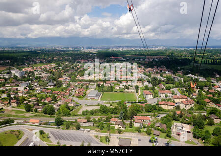 Verstreute Häuser in der ganzen grünen Landschaft bei bewölktem Himmel erfüllt, als aus dem Mont Salève Seilbahn in Frankreich gesehen. Stockfoto