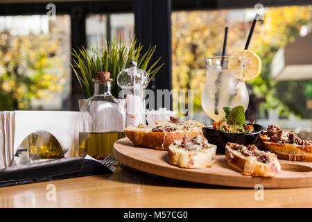 Breakfast Sandwich - mit knusprigem Speck, Wachtelei, Tomaten, Ziegenkäse, grüne Erbsen, Radieschen, Gurken auf rustikalen Schneidebrett. Gesunden Snack. Stockfoto