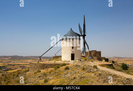 CONSUEGRA, SPANIEN. 24. Juni 2016 Gruppe von Windmühlen im Alcázar de San Juan und Castillo de La Muela im Hintergrund. La Mancha, Consuegra, Don Quixote Stockfoto