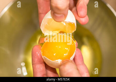 Eine Frau mit einem offenen Hühnerei in den Händen. Stockfoto