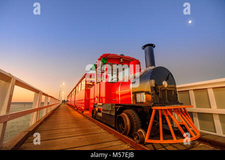 Perspektivische Ansicht von Busselton Jetty Zug in Busselton, Western Australia an der blauen Stunde. Die malerische Landschaft der berühmten Wahrzeichen bei Sonnenuntergang. Busselton Jetty ist die längste hölzerne Seebrücke in der Welt. Stockfoto