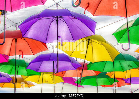 Mehrere bunte Sonnenschirme hängen Overhead außerhalb eines speichern. CS6 Filtration angewendet. Stockfoto