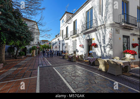 MARBELLA, SPANIEN - Dezember 2017: Zwei Frauen sind zu Fuß entlang der schönen Straße mit Häusern. Stockfoto