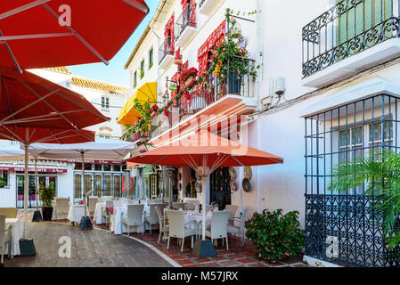 MARBELLA, SPANIEN - Dezember 2017: Traditionelle spanische Straße mit weißen Architektur und Cafes entlang. Stockfoto