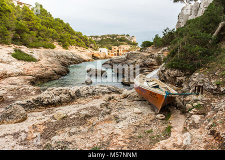 Ein kleines Fischerboot Strände am Mittelmeer Wasser in den Caló des Moro auf der Insel Mallorca, Spanien. Stockfoto